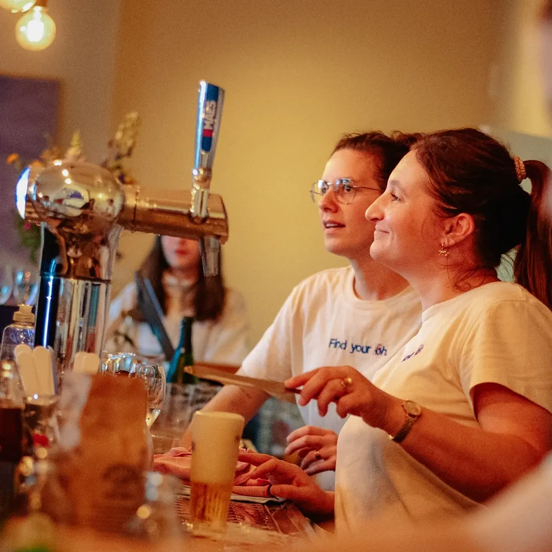 Natalie en Alison achter de toog van BarOH, met een vers getapt bier